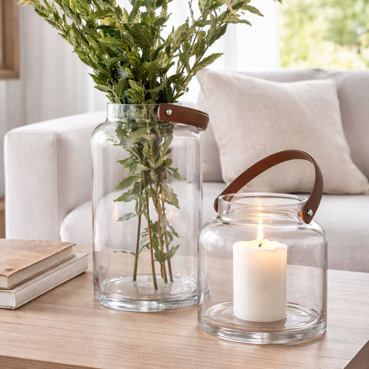 Pair of hand-blown glass lantern vases with leather-look handles styled in neutral living space