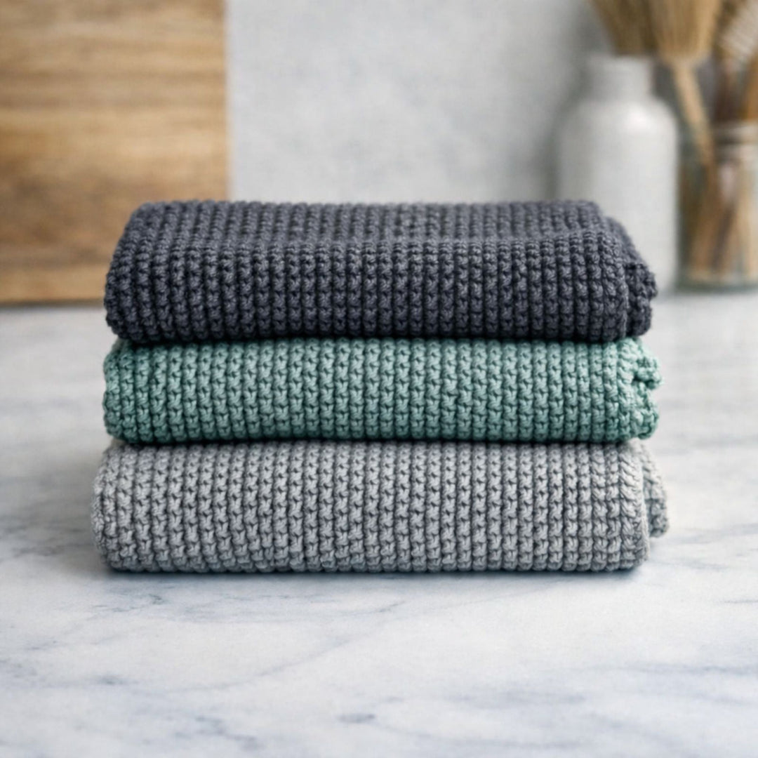 Stacked organic cotton dish cloths in charcoal, sage green and light grey – eco friendly reusable kitchen cloths